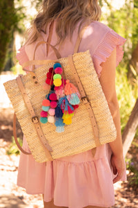 Handmade straw backpack with colorful tassel pom poms