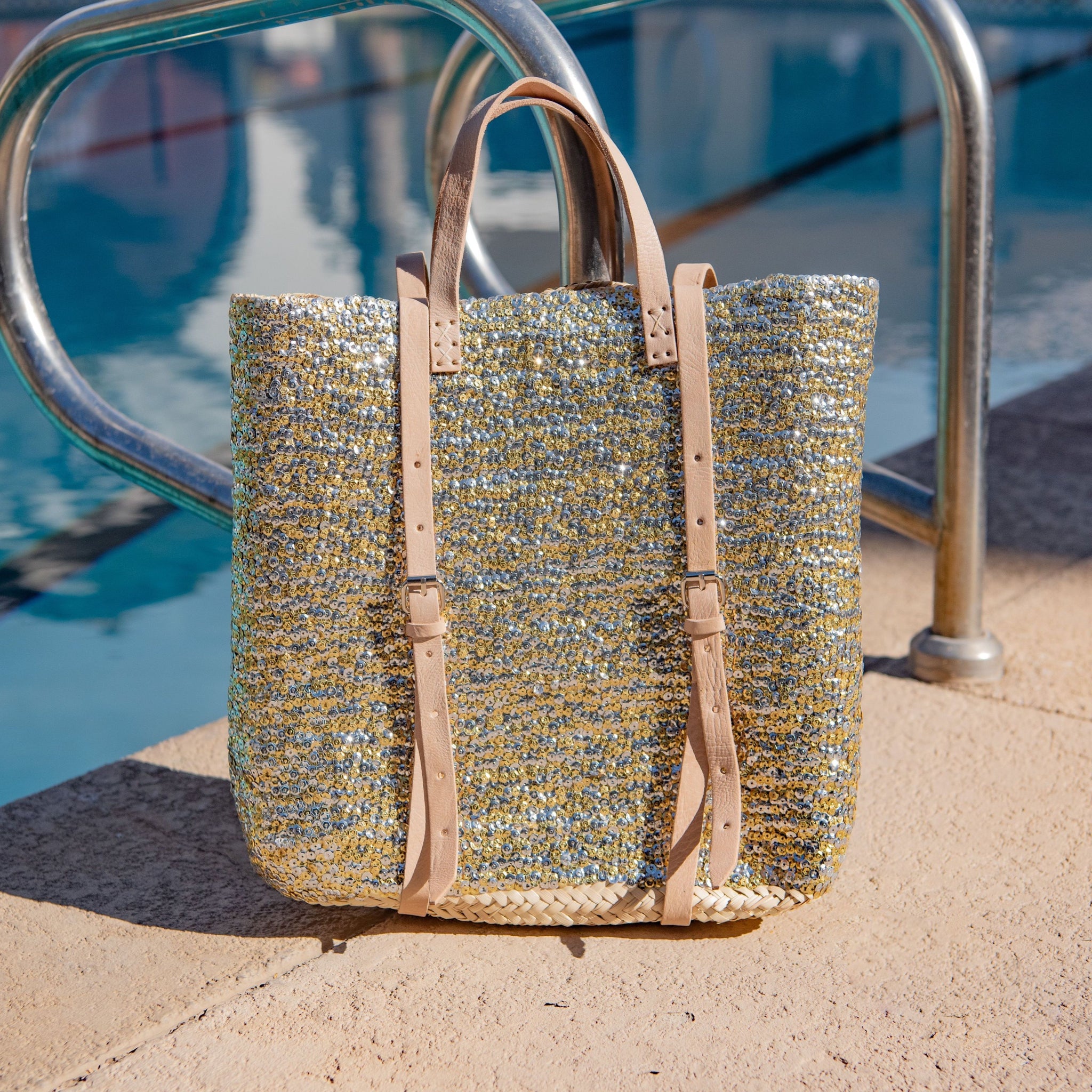 Straw Backpack with Silver and Gold Sequins sitting next to pool