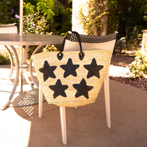 Large Straw Bag with Black Sequin Stars hanging on a chair