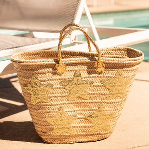 Large Straw Bag with Gold Sequin Stars sitting by pool