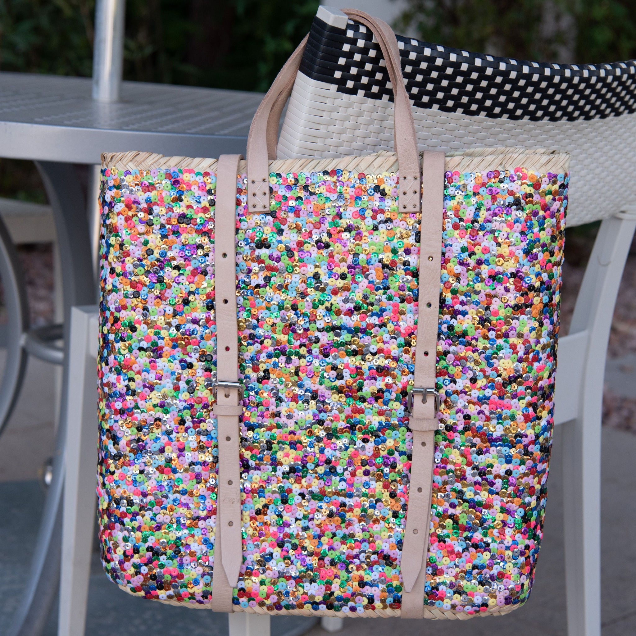 Straw Backpack with Multi-Colored Sequin sitting on back of chair