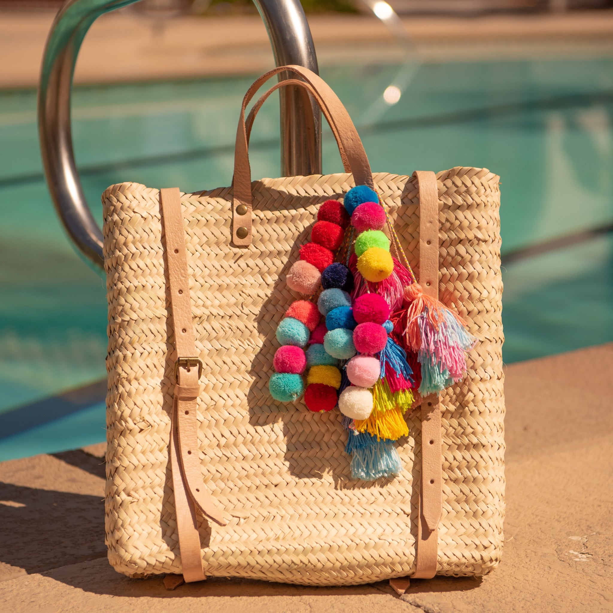 Handcrafted Straw Backpack sitting by pool