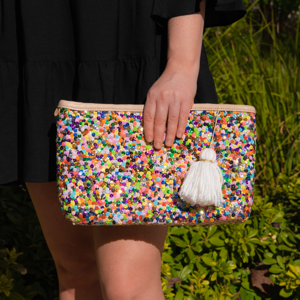 Girl holding straw clutch with multi-colored sequins