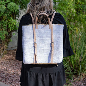 Woman wearing straw backpack with white sequins 